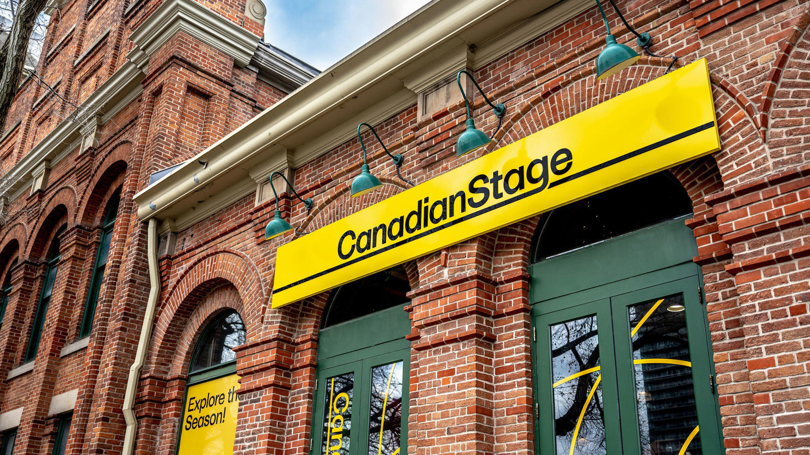 A red brick building with a Canadian Stage sign above the door