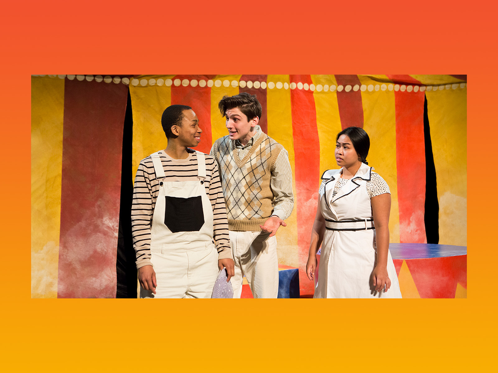 three people in front of a circus tent