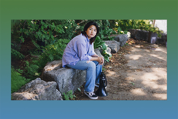 a girl sitting in a park holding a megaphone