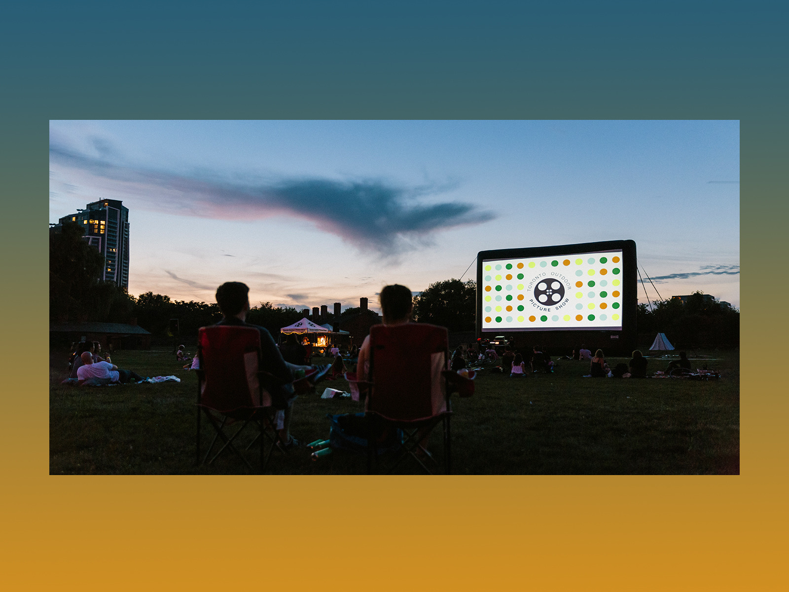 people watching a movie screen on the grass
