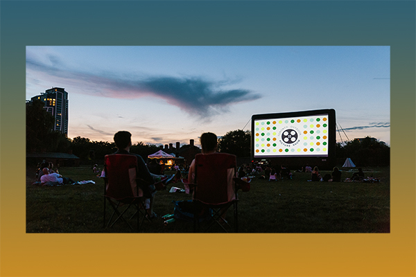 people watching a movie screen on the grass