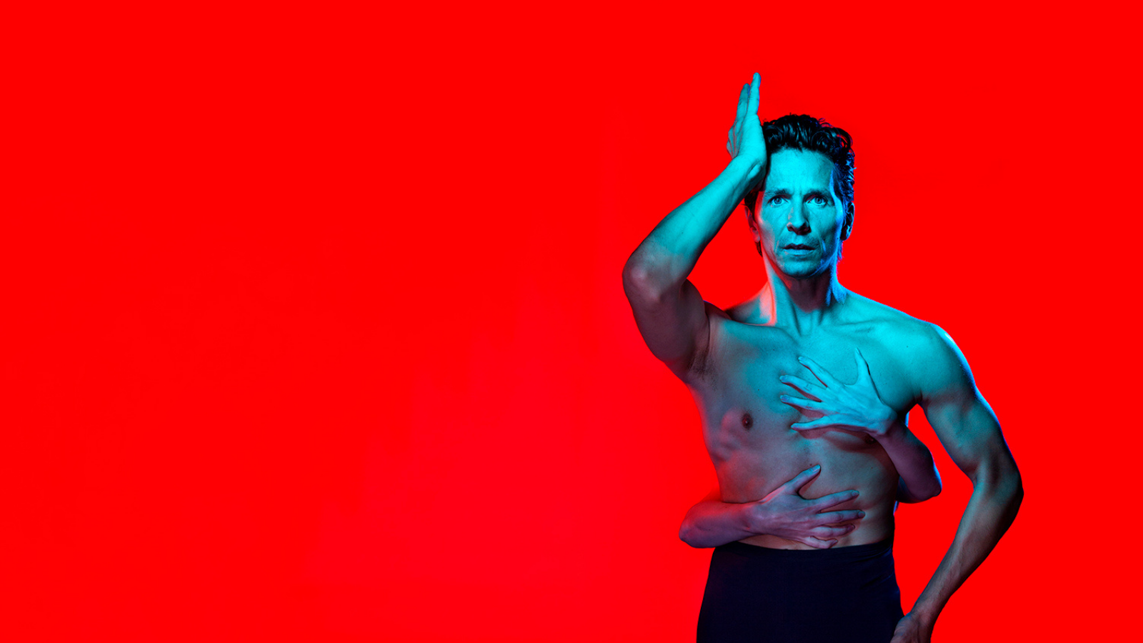 a man in front of a red backdrop