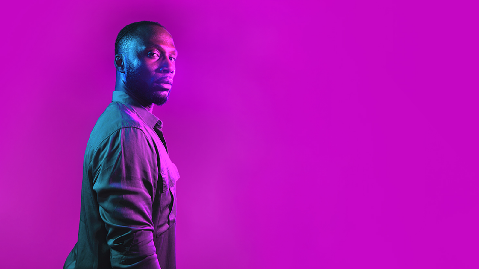 a man in front of a neon pink background