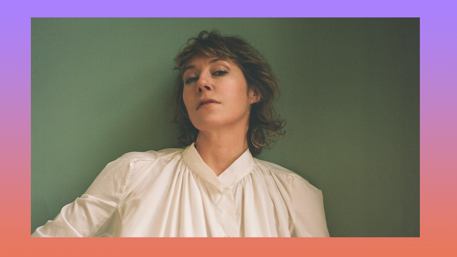 Martha Wainwright, in white blouse, tilts her head back and stares into the camera